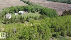 Aerial perspective showcasing two distinct structures amidst expansive greenery - 