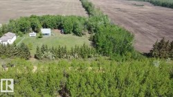 Expansive property featuring a cleared building site, mature trees, and agricultural land - 