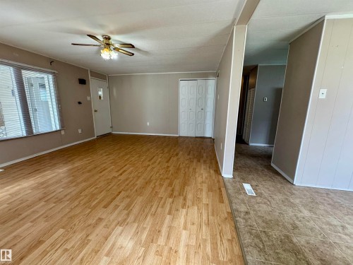 Open concept living space featuring wood-finish flooring, neutral wall tones, and a ceiling fan with integrated lighting - #46 4204 47 St, Wetaskiwin, AB - Indoor Photo Showing Other Room