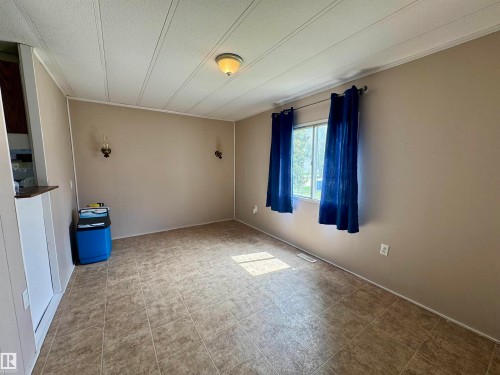 Room featuring neutral tone walls and large window - #46 4204 47 St, Wetaskiwin, AB - Indoor Photo Showing Other Room