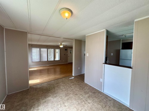 Open-concept interior featuring light gray wall paneling and a ceiling-mounted light fixture - #46 4204 47 St, Wetaskiwin, AB - Indoor Photo Showing Other Room