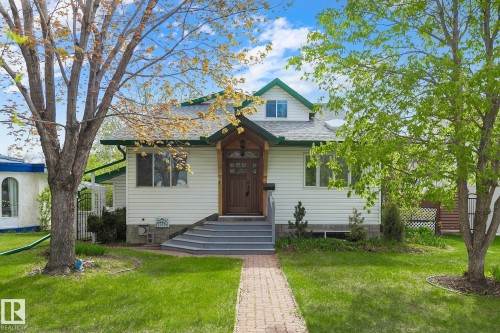 Charming white siding exterior with green trim accents and a pitched roofline - 10823 130 Street, Edmonton, AB - Outdoor