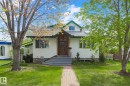 Charming white siding exterior with green trim accents and a pitched roofline - 10823 130 Street, Edmonton, AB  - Outdoor 