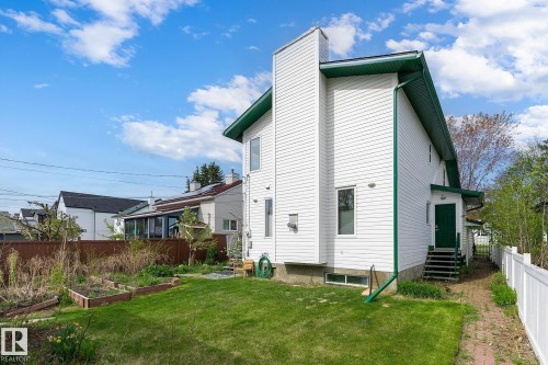 White siding exterior with green trim and a prominent chimney feature - 10823 130 Street, Edmonton, AB - Outdoor