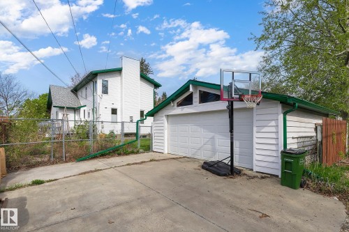 Detached two-car garage with a white sectional door and green trim - 10823 130 Street, Edmonton, AB - Outdoor With Exterior