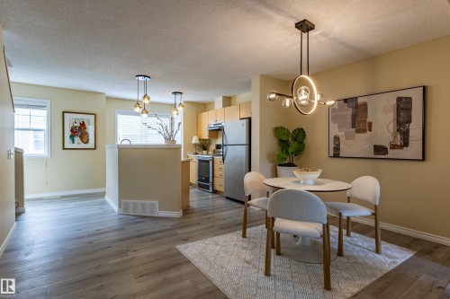 Open-concept living area with wood-finish flooring, recessed lighting, and ample natural light from multiple windows - 41 8304 11 Avenue, Edmonton, AB - Indoor Photo Showing Dining Room