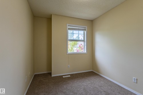 Room featuring a window with white trim, light-colored walls, and brown carpet flooring - 41 8304 11 Avenue, Edmonton, AB - Indoor Photo Showing Other Room
