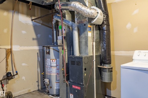 Mechanical room featuring a water heater, furnace, and exposed ductwork - 41 8304 11 Avenue, Edmonton, AB - Indoor Photo Showing Basement