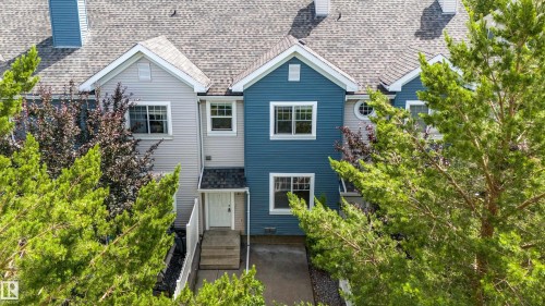 Multi-level townhouse exterior featuring blue and light gray siding, white trim, and a gray shingle roof - 41 8304 11 Avenue, Edmonton, AB - Outdoor