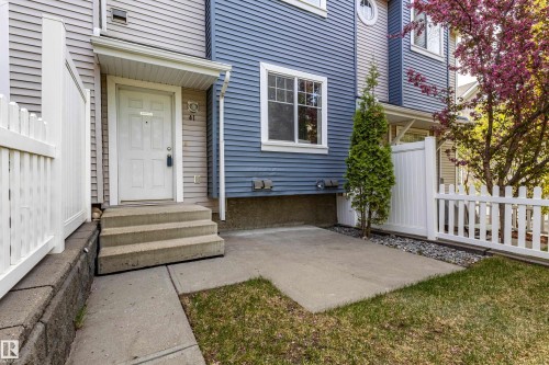 Front exterior of a multi-level residence featuring blue and grey horizontal siding - 41 8304 11 Avenue, Edmonton, AB - Outdoor