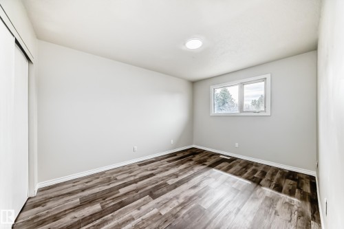 Interior room with wood-finish flooring, white baseboards, and light gray walls - 8615 42A Avenue, Edmonton, AB - Indoor Photo Showing Other Room