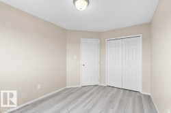 Room featuring wood-finish flooring, neutral wall paint, white trim, and a ceiling-mounted light fixture - 