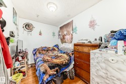 Room featuring wood-finish flooring, white walls, and an overhead flush-mount light fixture - 