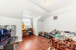 Room featuring wood-finish flooring and a sloped ceiling - 