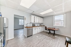 Kitchen featuring white cabinetry, wood-finish countertops, stainless steel appliances, and light wood-finish flooring - 