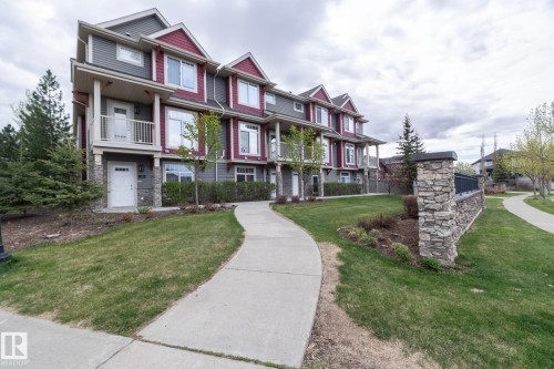 Contemporary multi-story townhome with a distinctive red and gray exterior - 117 Callaghan Drive Sw, Edmonton, AB - Outdoor With Facade