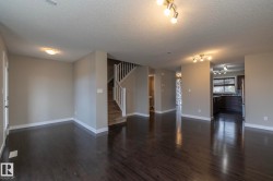 Spacious interior featuring dark wood-finish flooring, light neutral-toned walls, and white trim throughout - 