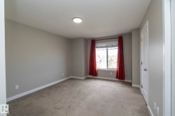 Neutral-toned walls and plush carpeting with white trim and a white two-panel door - 