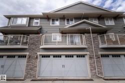 Multi-level exterior featuring horizontal siding and stone veneer accents - 