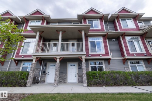 Townhome exterior featuring gray horizontal siding and red shake accents - 117 Callaghan Drive Sw, Edmonton, AB - Outdoor With Facade