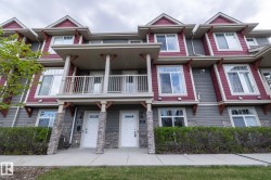 Townhome exterior featuring gray horizontal siding and red shake accents - 