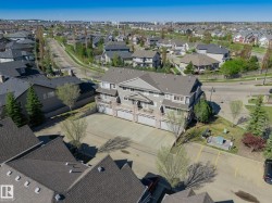 Multi-level residential building featuring private balconies, individual garage doors, and a paved parking area - 