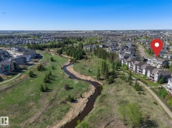 Aerial depiction of a residential area featuring a winding natural watercourse - 