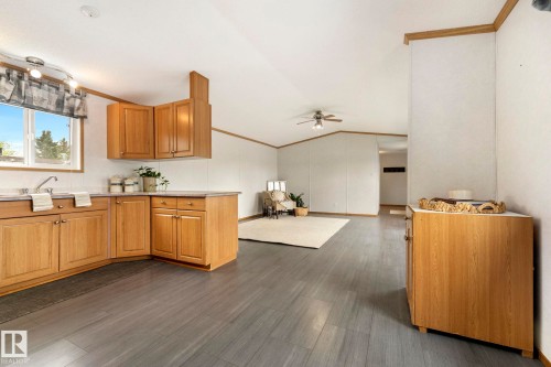 Kitchen area featuring wood-finish cabinetry, a stainless steel sink, and light countertops - 49 Rim Road Nw, Edmonton, AB - Indoor Photo Showing Kitchen