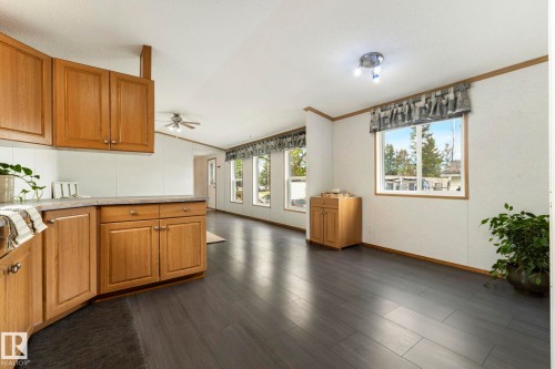 Spacious living area featuring dark wood-finish flooring, white walls with accent trim, and multiple windows providing natural light - 49 Rim Road Nw, Edmonton, AB - Indoor Photo Showing Kitchen