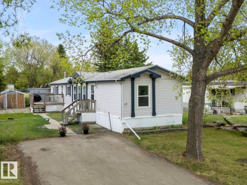 Single-story residence featuring light-colored siding and dark trim accents - 49 Rim Road Nw, Edmonton, AB - Outdoor