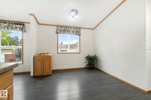 Spacious interior room featuring dark wood-finish flooring and two large windows - 49 Rim Road Nw, Edmonton, AB - Indoor Photo Showing Other Room