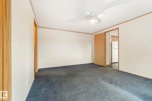 Spacious room featuring paneled walls, wood-finish trim, and blue carpeting - 49 Rim Road Nw, Edmonton, AB - Indoor Photo Showing Other Room