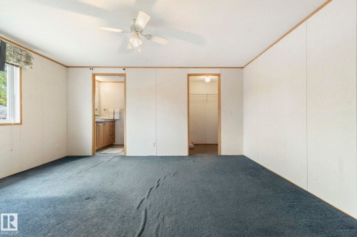 Spacious interior with blue carpeting, white paneling, and wood-trim accents - 49 Rim Road Nw, Edmonton, AB - Indoor Photo Showing Other Room