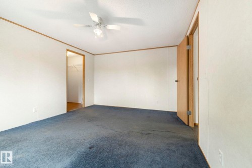 Carpeted room featuring a ceiling fan with light, white paneled walls, and wood-finish trim - 49 Rim Road Nw, Edmonton, AB - Indoor Photo Showing Other Room