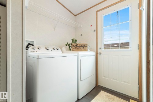 Dedicated laundry area featuring wire shelving, durable flooring, and direct exterior access - 49 Rim Road Nw, Edmonton, AB - Indoor Photo Showing Laundry Room