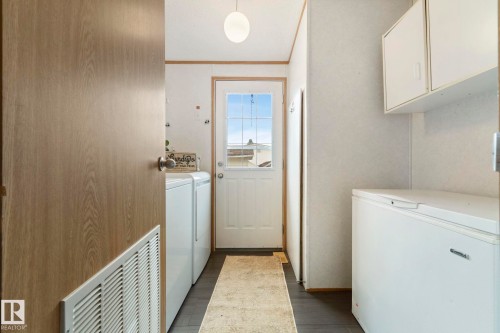 Mudroom area featuring a white paneled door with window panes, white upper cabinetry, and dark-finish flooring - 49 Rim Road Nw, Edmonton, AB - Indoor