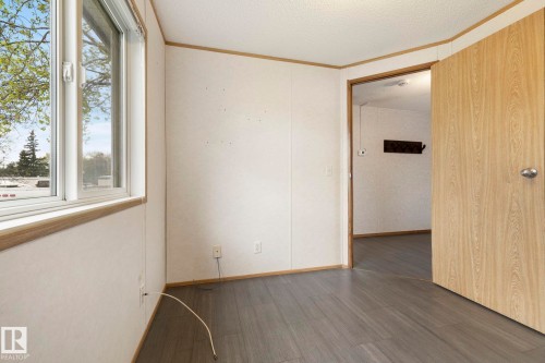 Room featuring wood-finish flooring, white panel walls, and a window with white trim - 49 Rim Road Nw, Edmonton, AB - Indoor Photo Showing Other Room