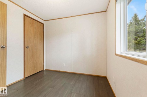 Room featuring wood-finish flooring, a wood-finish door, and a multi-pane window with outdoor scenery - 49 Rim Road Nw, Edmonton, AB - Indoor Photo Showing Other Room
