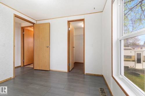 Interior space featuring wood-finish doors, white walls, and contemporary gray tile flooring - 49 Rim Road Nw, Edmonton, AB - Indoor Photo Showing Other Room