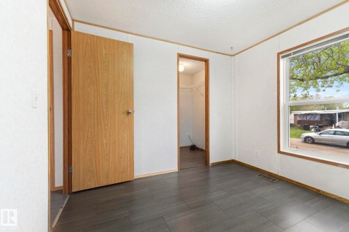 Room featuring dark wood-finish flooring, white walls, and a large window with wood trim - 49 Rim Road Nw, Edmonton, AB - Indoor Photo Showing Other Room