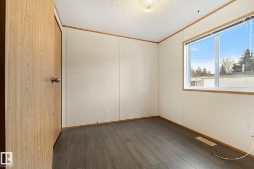 Room featuring wood-finish flooring, a light-colored door, and a large window - 49 Rim Road Nw, Edmonton, AB - Indoor Photo Showing Other Room