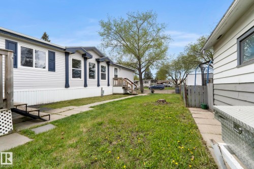 White vinyl siding exterior with blue decorative shutters and trim - 49 Rim Road Nw, Edmonton, AB - Outdoor