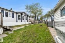 White vinyl siding exterior with blue decorative shutters and trim - 49 Rim Road Nw, Edmonton, AB  - Outdoor 