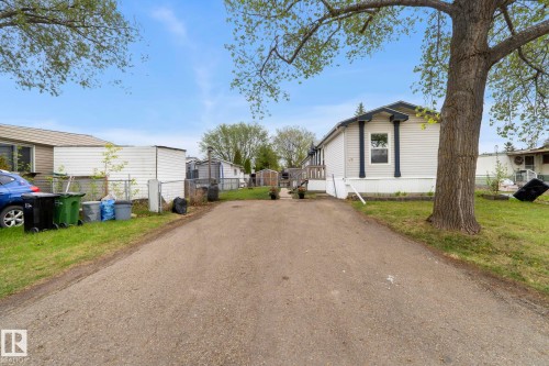 White siding exterior with dark trim accents and an asphalt driveway - 49 Rim Road Nw, Edmonton, AB - Outdoor