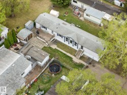 Aerial perspective showcasing a single-story residence with a light-colored exterior and dark trim accents - 