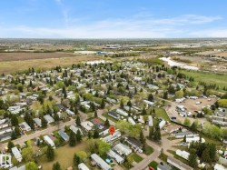 Aerial perspective showcasing a residential community with numerous detached properties and established trees - 