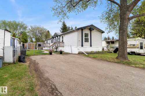 Exterior siding with dark trim accents, featuring a front entry deck with wooden stairs - 49 Rim Road Nw, Edmonton, AB - Outdoor