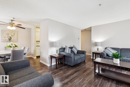 This property features dark hardwood flooring throughout the main living areas - 202 17511 98A Avenue, Edmonton, AB - Indoor Photo Showing Living Room
