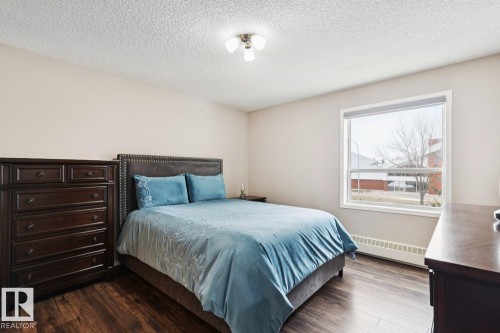 This room features hard surface flooring, a window providing natural light, and a ceiling-mounted light fixture - 202 17511 98A Avenue, Edmonton, AB - Indoor Photo Showing Bedroom
