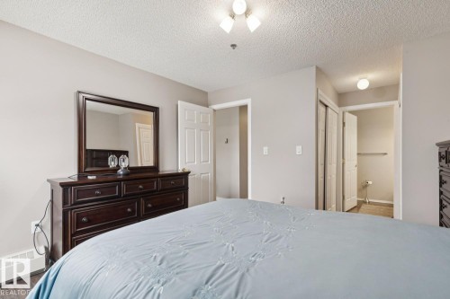 This room features neutral wall colors and dark hardwood floors - 202 17511 98A Avenue, Edmonton, AB - Indoor Photo Showing Bedroom